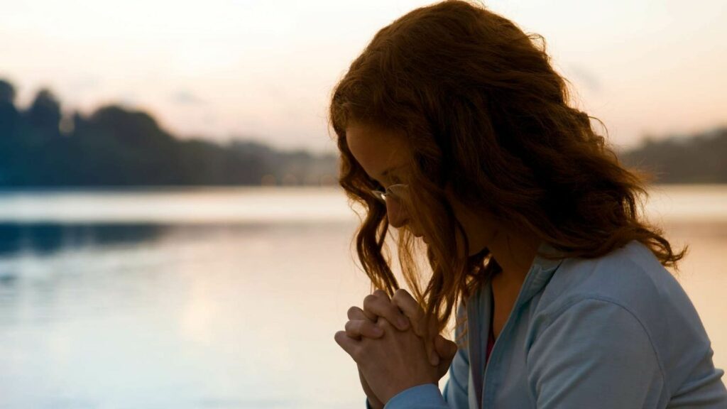 woman at lake praying